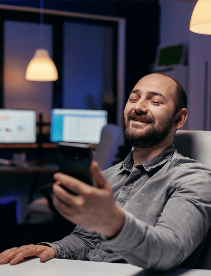 1488a427-cheerful-entrepreneur-saying-hello-talking-video-call-using-phone-businessman-course-important-video-conference-while-doing-overtime-office_10n20ss000000000000028